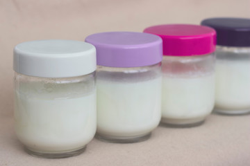 Portion of fresh natural homemade organic yogurt in a glass bowl with colored covers