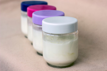 Portion of fresh natural homemade organic yogurt in a glass bowl with colored covers