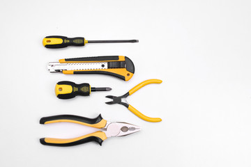 Black yellow tools - knife, pliers, tape measure, screwdriver, nippers on a white background. Place for text. Work inventory