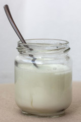 white yogurt in glass jar on table for breakfast