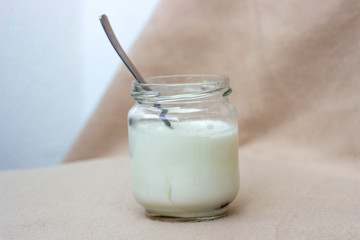 white yogurt in glass jar on table for breakfast