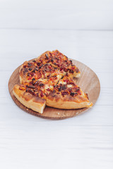 Homemade pizza on white wooden background on kitchen board