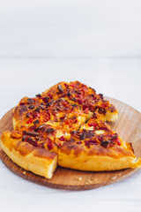 Homemade pizza on white wooden background on kitchen board