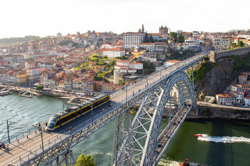 Fototapeta na wymiar Aerial view of Dom Luis I Bridge with metro train across Douro River, the famous postcard of Porto, Portugal