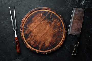 The old kitchen knife and Wooden boards on a black background. Top view. Free space for your text.