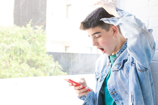 surprised or frightened young man watching the mobile phone