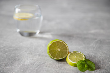 Pokorojona limonka w oddali szklanka z wodą