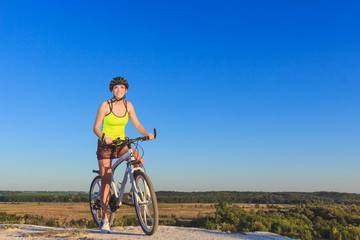 Obraz premium Young beautiful woman with a sport bike, soft focus background