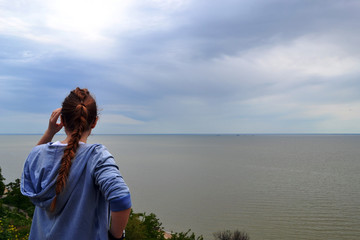 a woman in a bonnet is looking at the sea