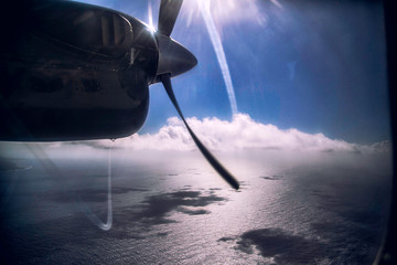 propeller plane flying in the sky over above clouds sky background
