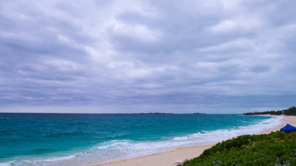 Fototapeta na wymiar Cloudy day over a beach in Nassau and a view of the Atlantic Ocean. Paradise Island, The Bahamas.