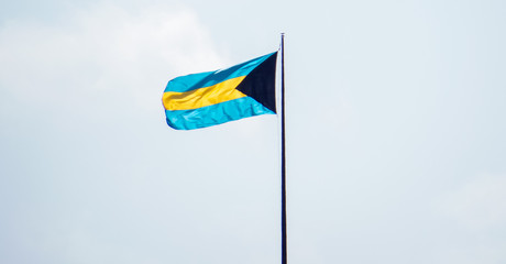 The Bahamian flag waving in the warm wind of the tropics.
