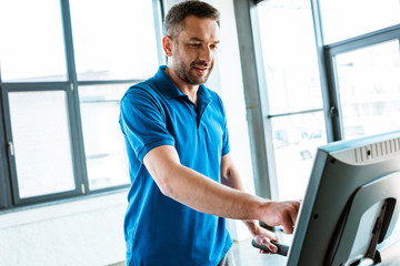 handsome man exercising on treadmill at gym