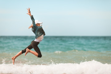 Young girl jumping in the air on the beach