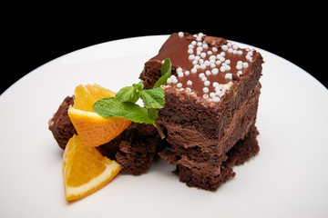 Chocolate cake with orange on a white dish.