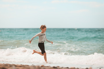 Young girl running through the waves at the beach