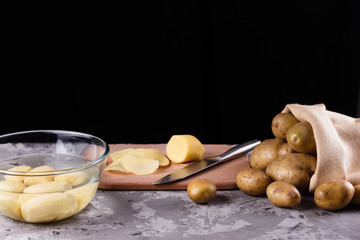 young woman in an apron cuts potatoes