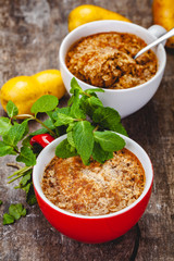 Apple crumble in two cups on wooden rustic background. Close up