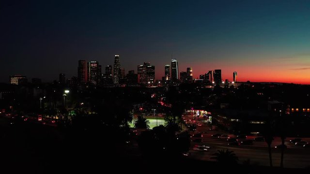 Aerial riser view of downtown Los Angeles in California USA after sunset during twilight with cars moving in traffic on freeway
