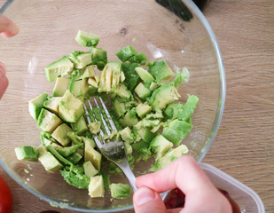 Making avocado spread in the kitchen, masing avocado with a fork