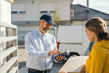 Fototapeta premium woman paying with debit card for delivery service