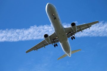 Fototapeta na wymiar Passagierflugzeug in der Luft und blauer Himmel und Kondensstreifen - Stockfoto