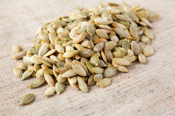 Roasted pumpkin seeds on cloth, side view. Close-up.