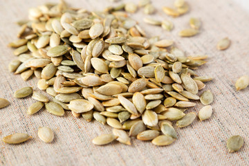Roasted pumpkin seeds on cloth, side view. Close-up.