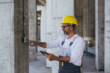 engineer in protective wear pushing button on construction site