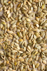 Roasted pumpkin seeds on cloth, top view. Flat lay, overhead, from above. Close-up.