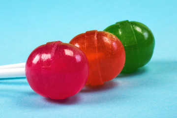 Colourful candies, a close-up at the blue background, a sweet notion of lollipops.