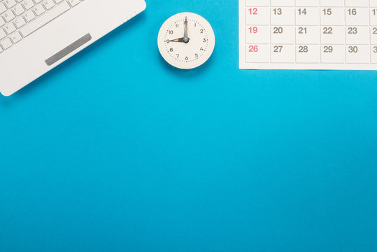 Calendar with dates, clock and keyboard on blue background 