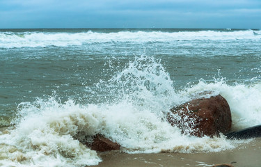 The waves crash on the rocks. Sea coast. Waves and storms at sea. Rocky shore.
