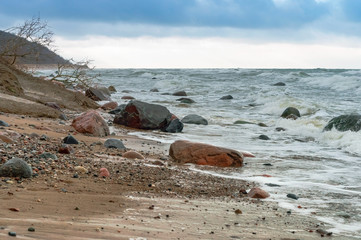 Fototapeta na wymiar The waves crash on the rocks. Sea coast. Waves and storms at sea. Rocky shore.