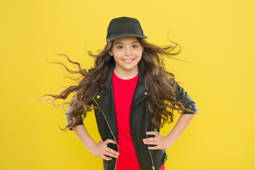 Girl adorable kid long wavy hair yellow background. Wind can also damage hair. Strong persistent...