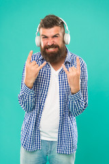 Heavy metal and hard rock. Streaming music sites. Wireless technology. Hipster with beard listening music. Handsome music lover. Man in headphones. User friendly interface and large library of tunes