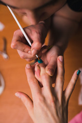 A woman makes a manicure with a thin brush. Salon procedures at home. close-up