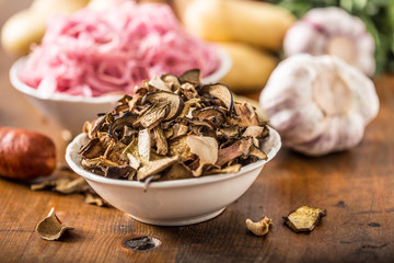 Dried mushrooms sour cabbage garlic and potatoes on wooden table