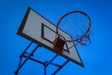 Naklejka premium Basketball basket on blue sky background. Basketball basket and board on the blue sky background.