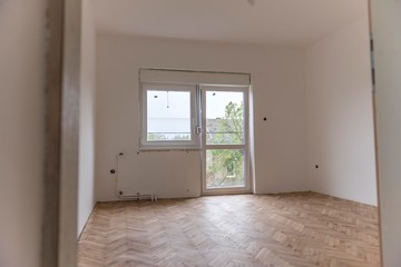 renovation of the house.white empty room with parquet and pvc windows.
