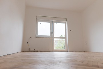 renovation of the house.white empty room with parquet and pvc windows.