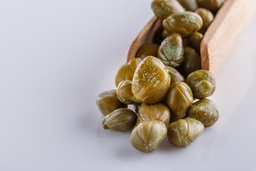 Pickled capers on a white acrylic background