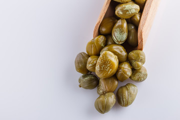Pickled capers on a white acrylic background