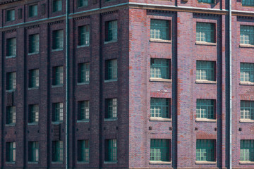Corner of an old industrial red Brickstone Building with many Windows