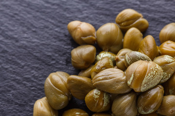 pickled capers on a dark stone background
