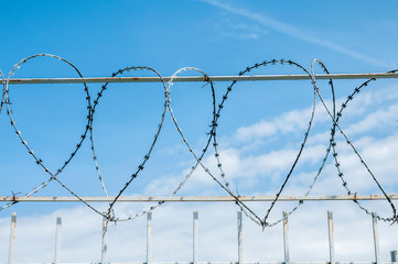 iron fence with barbed tape on blue sky