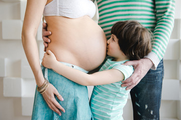 Portrait of happy little boy hugging mother's pregnant belly . New life concept. Happy second...