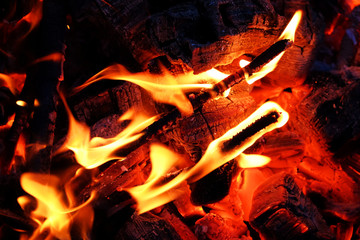 Glowing embers in hot red color, abstract background. The hot embers of burning wood log fire....