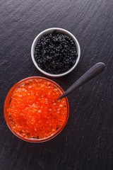 red and black caviar in a bowl on a dark stone background