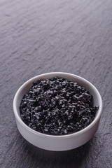 black caviar in a bowl on a dark stone background